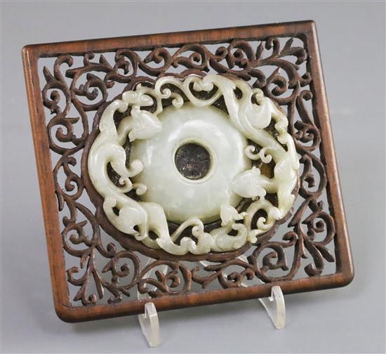 A Chinese archaistic pale celadon jade bi disc, 17th/18th century, Jade 8.3cm, frame 11cm x 12cm